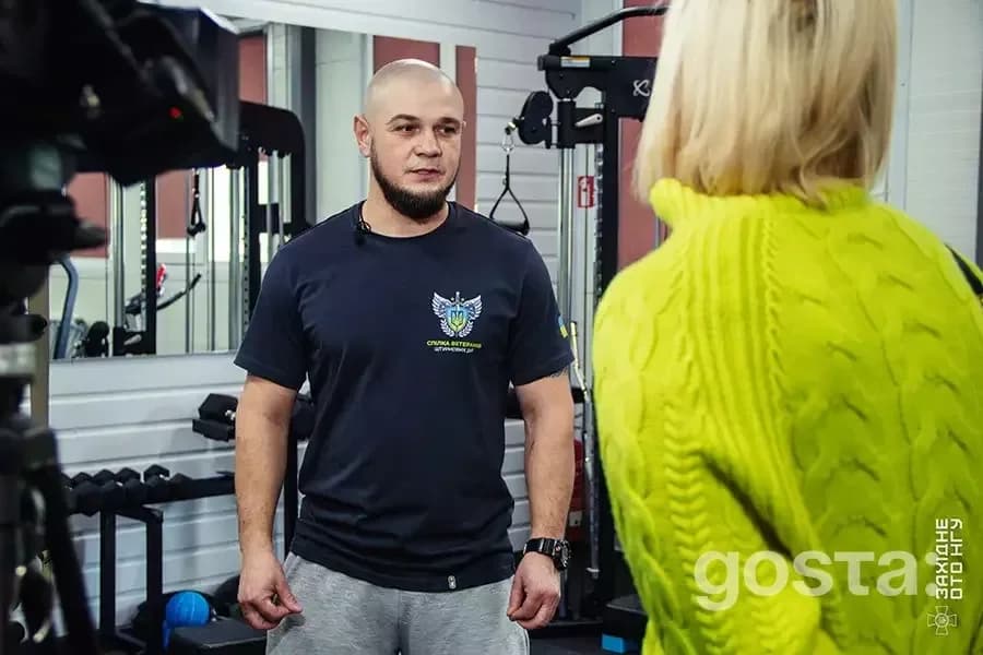 Чоловік у спортивній формі спілкується з жінкою в реабілітаційному центрі 50-го полку Нацгвардії України.