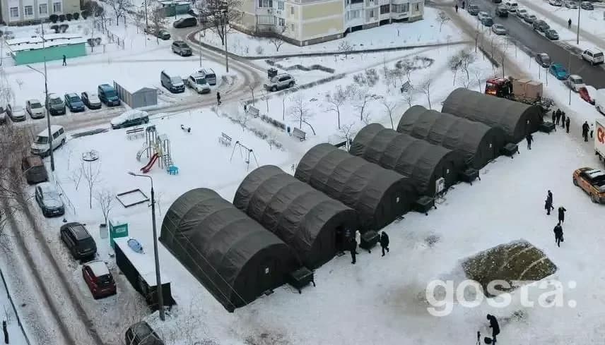 Намети обігріву у засніженому дворі Києва, встановлені для підтримки мешканців в умовах надзвичайної ситуації.