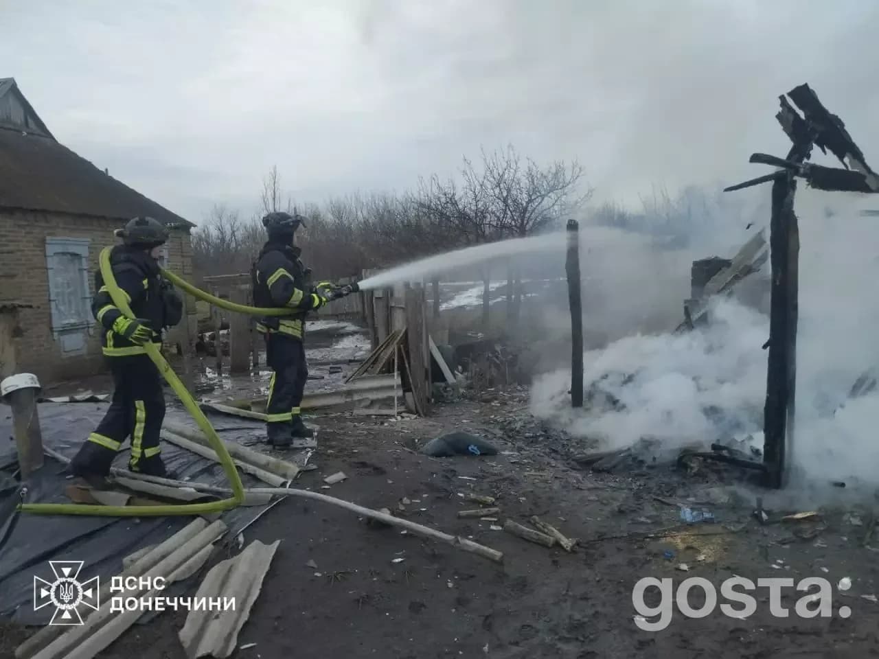 На зображенні пожежники гасять залишки зруйнованої будівлі під час відновлювальних робіт в Україні після обстрілу.