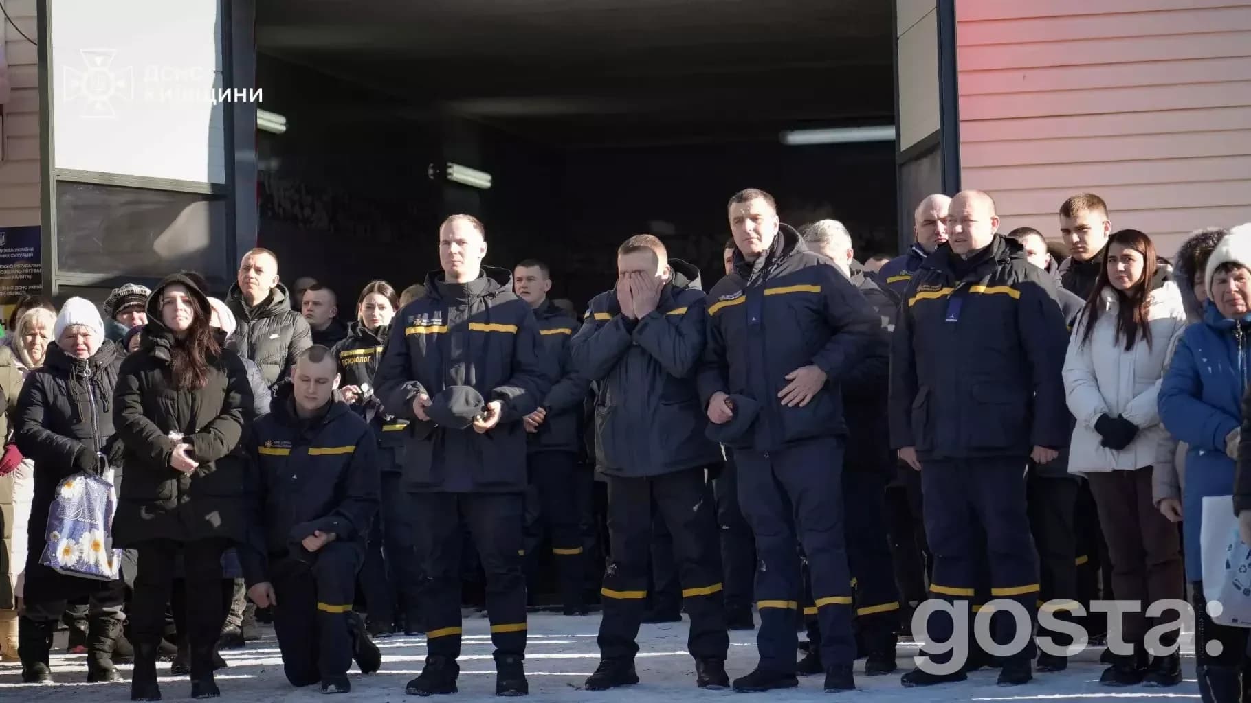 На зображенні натовп людей вказує на церемонію прощання з рятувальником, зібралися для вшанування його пам'яті.
