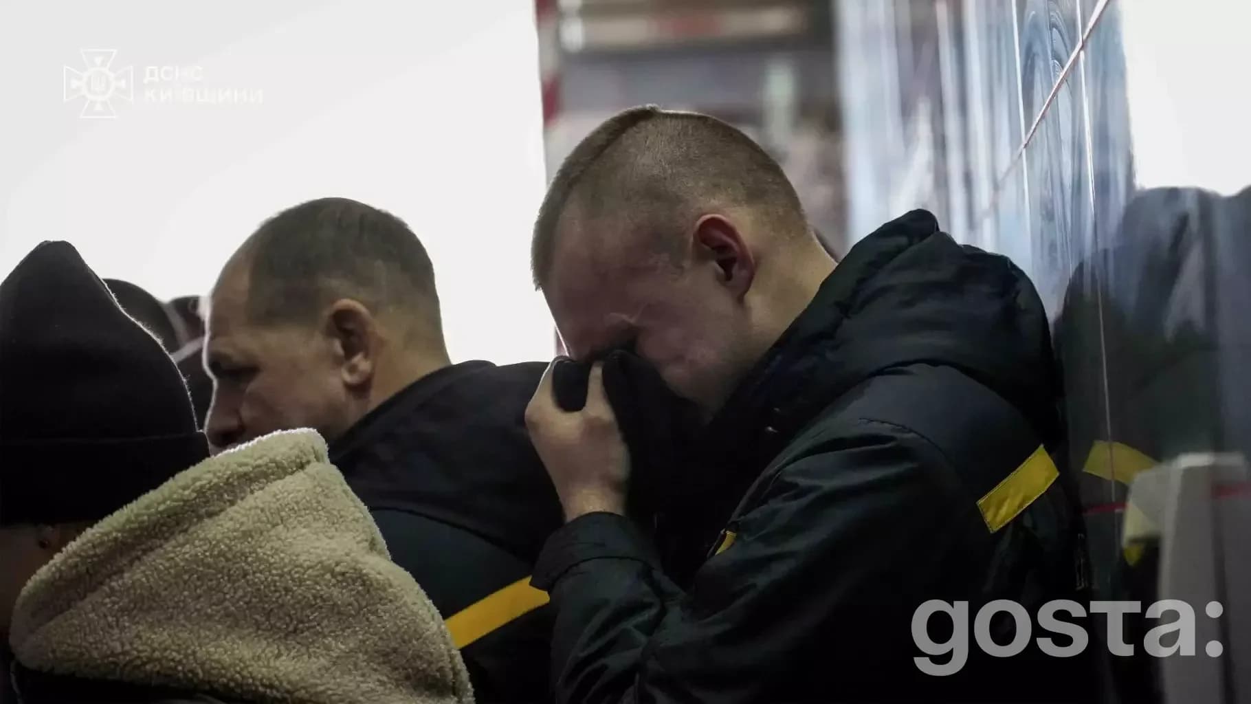 На зображенні: люди у формі ДСНС вшановують пам'ять рятувальника Михайла Проценка, один з них плаче, прикривши обличчя.