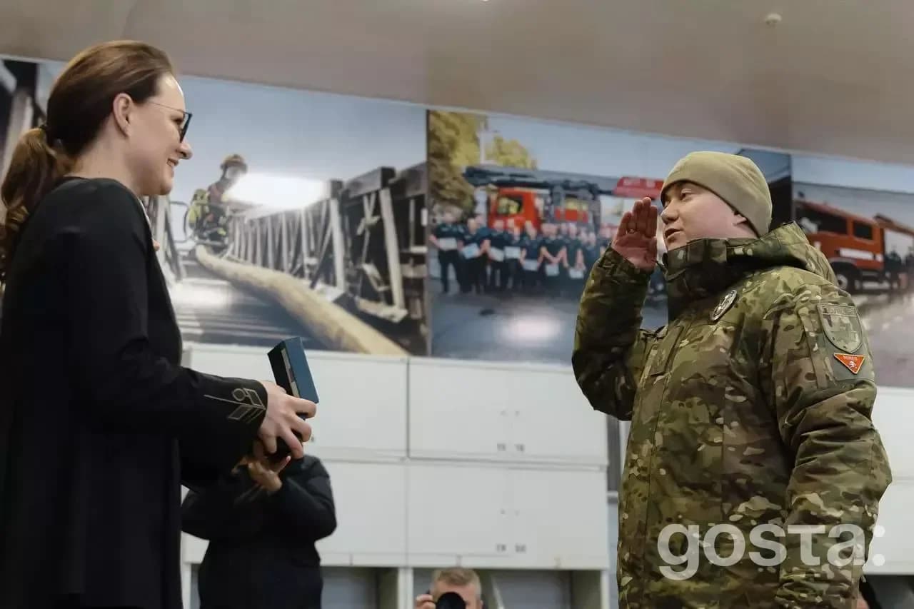 Юлія Свириденко вручає нагороду рятувальнику в камуфляжі під час офіційної церемонії.
