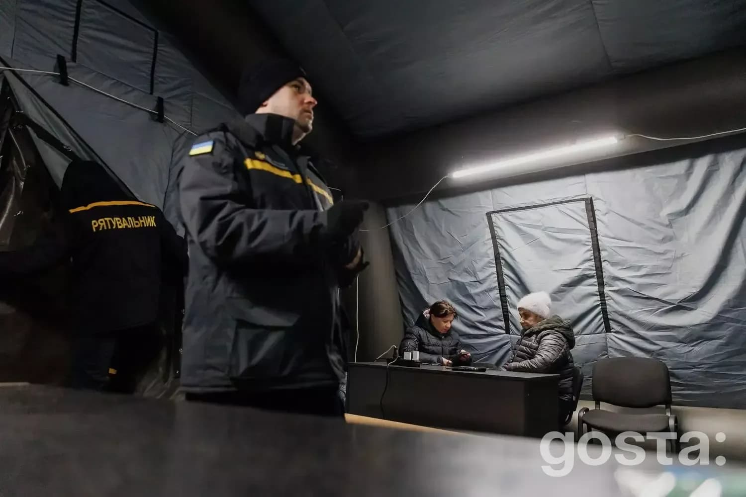 Люди в польовій палатці працюють надзвичайники під час кризи в Україні, обробляючи виклики лінії 112.