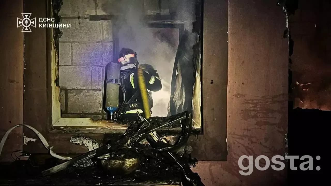 Firefighter battling flames in a damaged building after a Russian attack in Kyiv, highlighting the ongoing crisis.