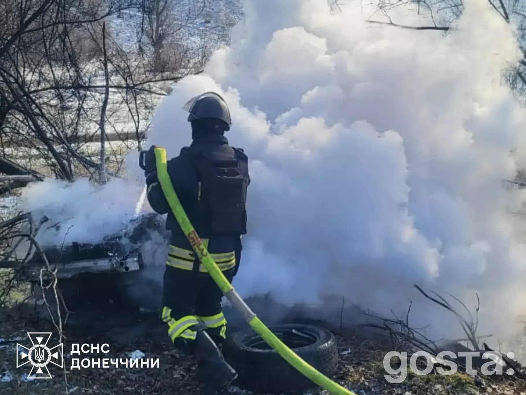 Пожежник гасить димляче полум'я на обстріляній території Донеччини, наслідки атак.