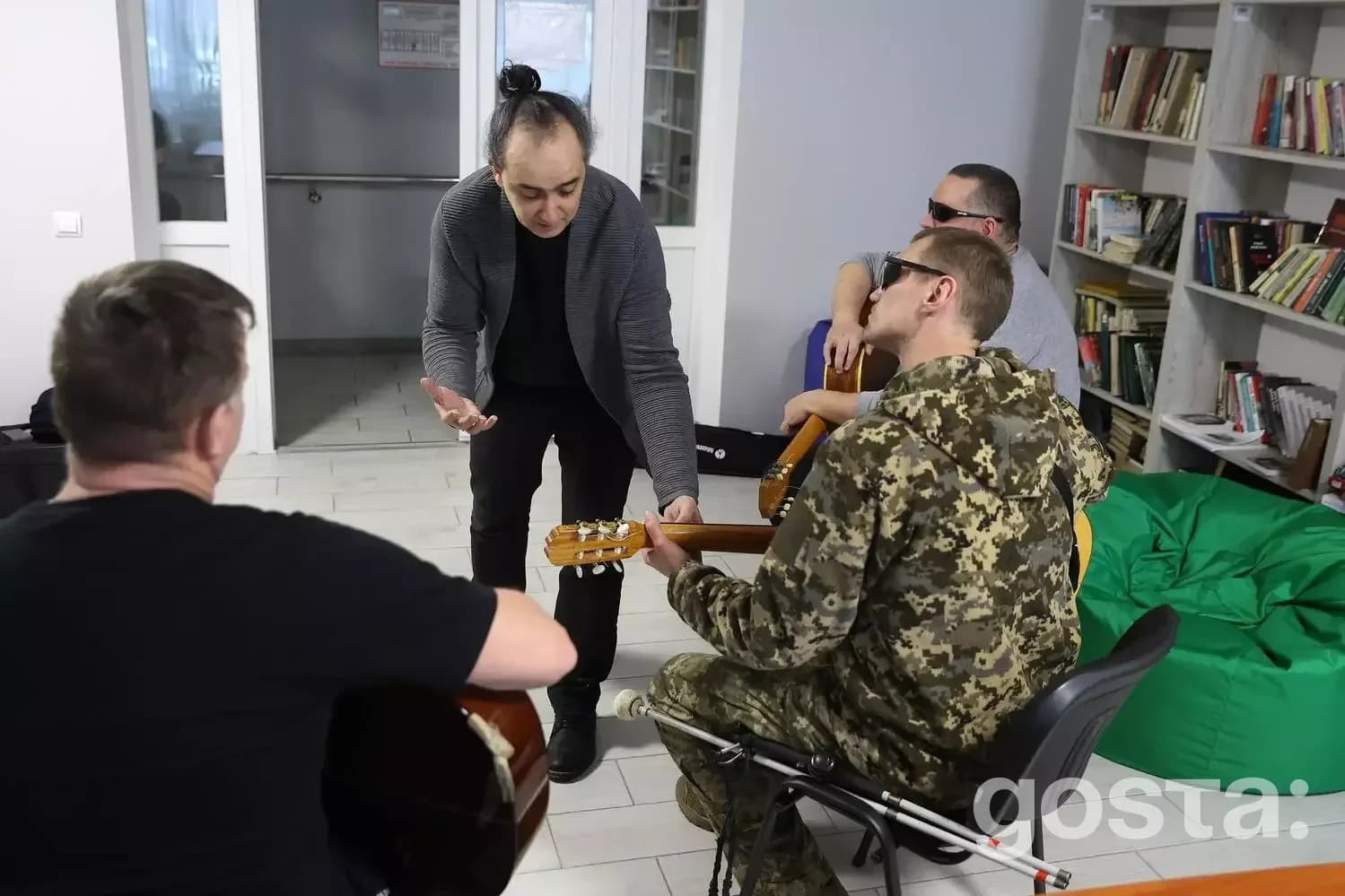 Ветерани у камуфляжі та цивільному одязі займаються музичною терапією у реабілітаційному центрі.