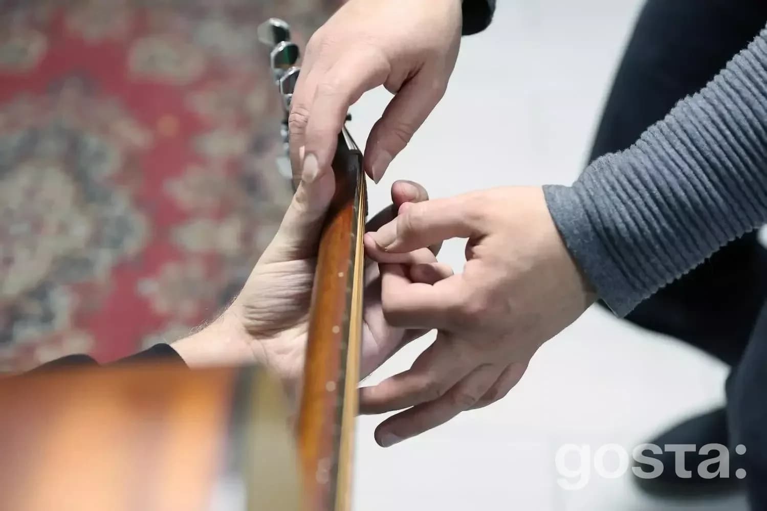 Людина навчається грати на гітарі під керівництвом інструктора, включаючись у процес реабілітації ветеранів.