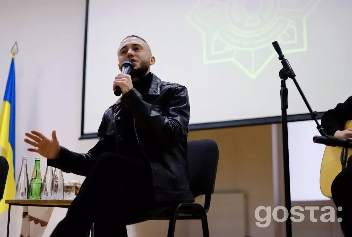 Лідер гурту «Антитіла» Тарас Тополя спілкується з ліцеїстами МВС в Івано-Франківську, сидячи з мікрофоном.