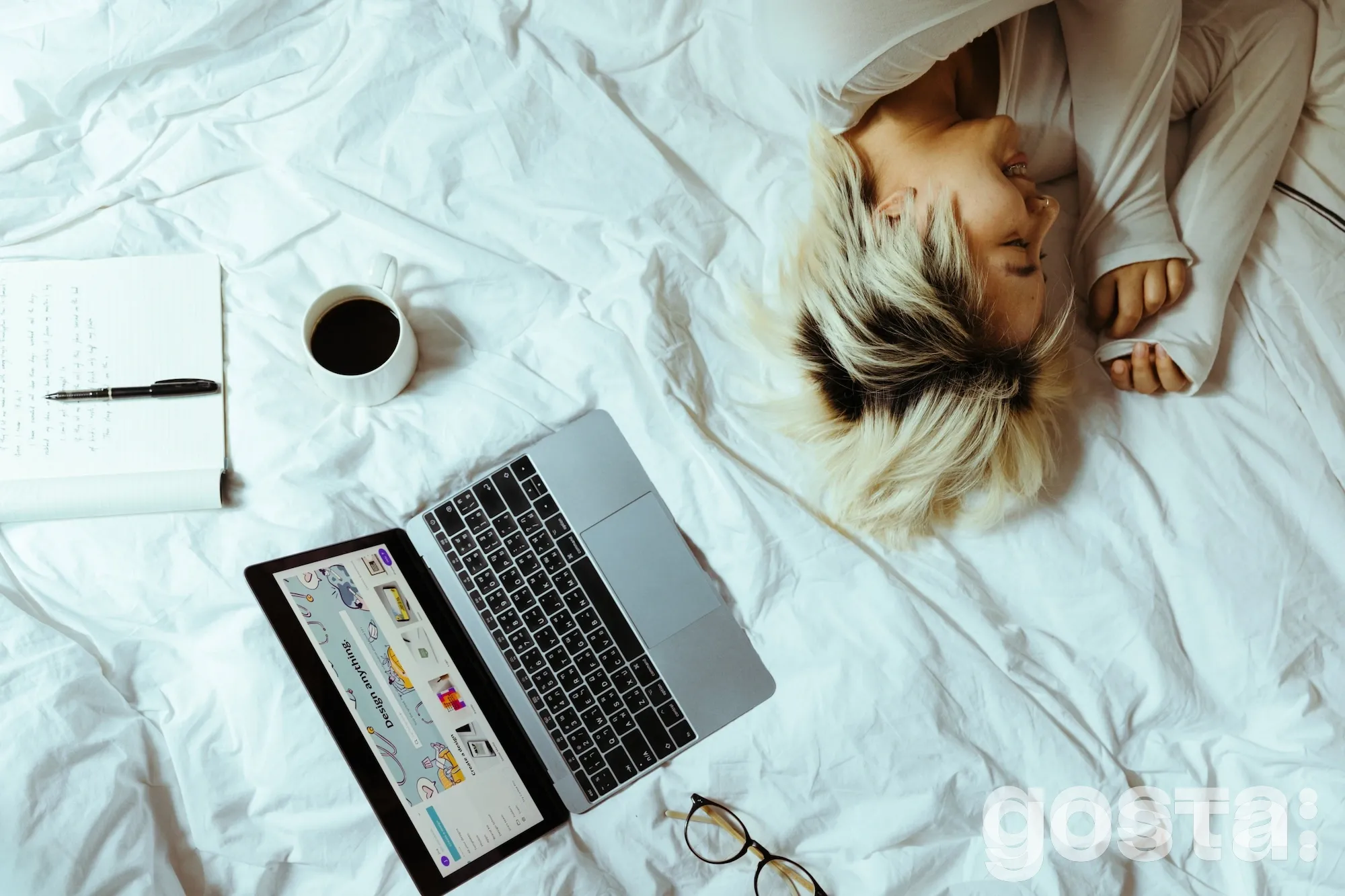 Жінка лежить на ліжку, поруч з ноутбуком та чашкою кави Прокрастинація – визначення та способи лікування