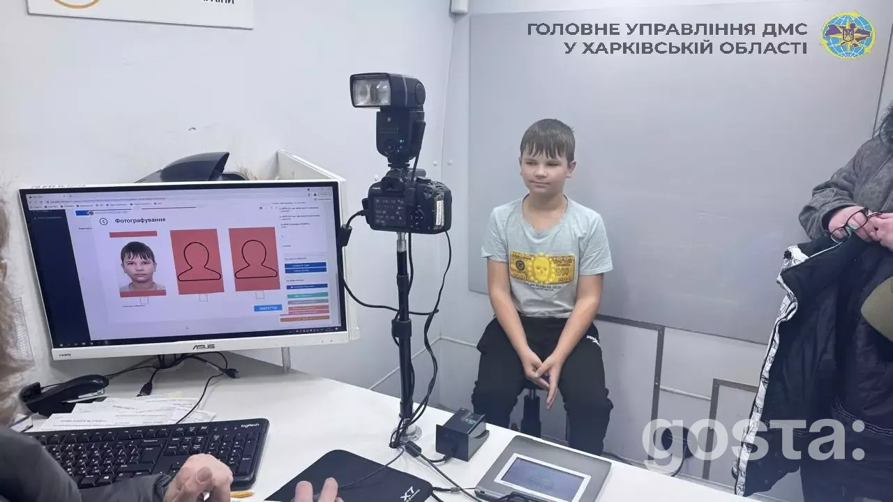 На зображенні показано дитину, що робить фото для біометричного паспорта у мобільному підрозділі ДМС України.
