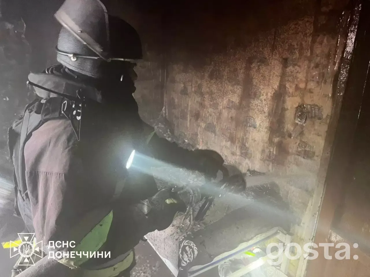 Firefighter extinguishing fire damage from drone attacks in Ukraine, showcasing the aftermath of the conflict.