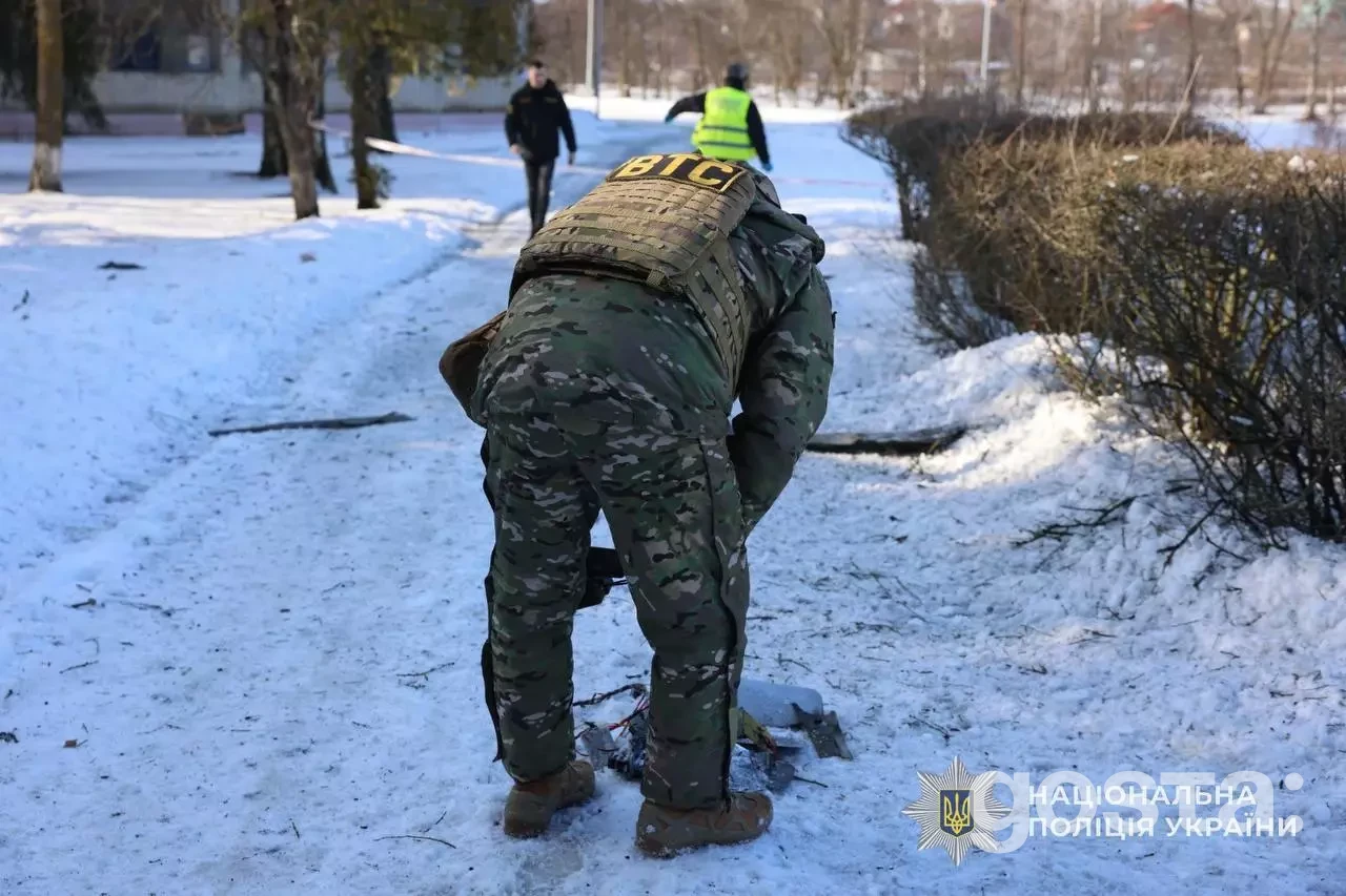 Поліцейський фіксує наслідки обстрілів на Київщині; зима, сніг, військова форма.