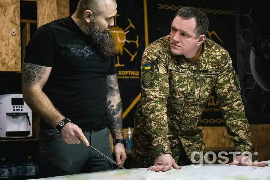 Командувач НГУ та військовий обговорюють стратегію на карті під час робочої поїздки на Харківщину.