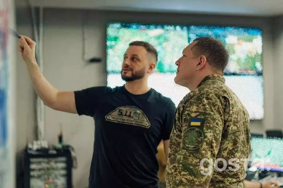 Двоє чоловіків обговорюють стратегії на фоні екранів у штабі Національної гвардії України в Харківській області.