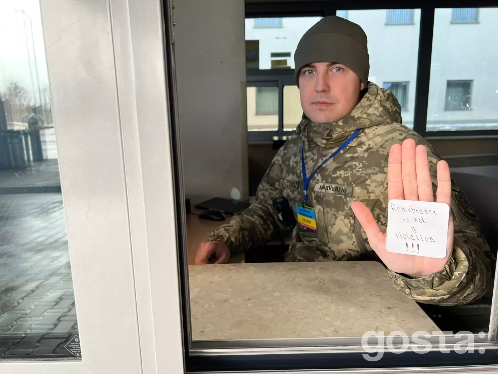 На зображенні військовий у формі з табличкою "Remembrance is not a violation".