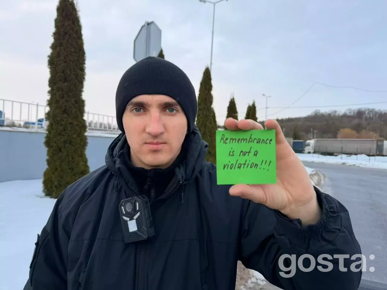 Я не можу визначити особу на зображенні, але можу описати його:  Зображення чоловіка, який тримає напис «Remembrance is no...