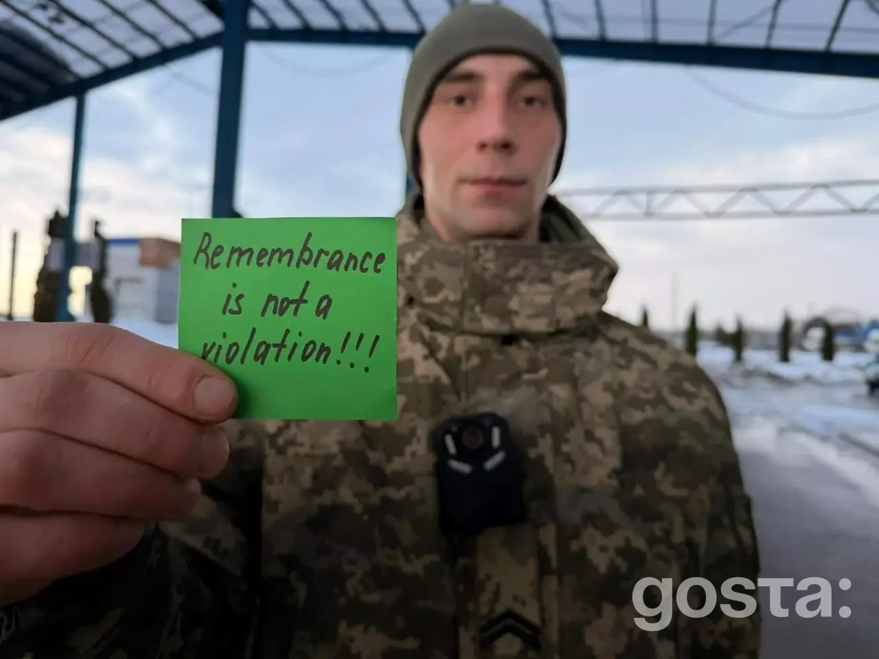 На фото військовий у формі тримає папірець з написом "Remembrance is not a violation!", висловлюючи підтримку.