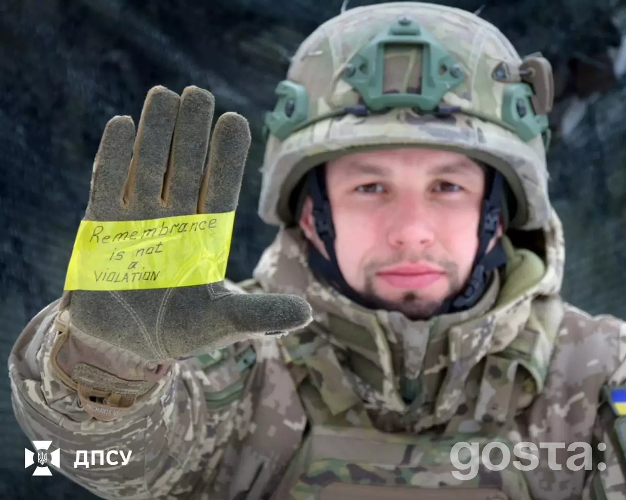 На зображенні військовослужбовець ДПСУ з написом "Remembrance is not a violation" на рукавиці.