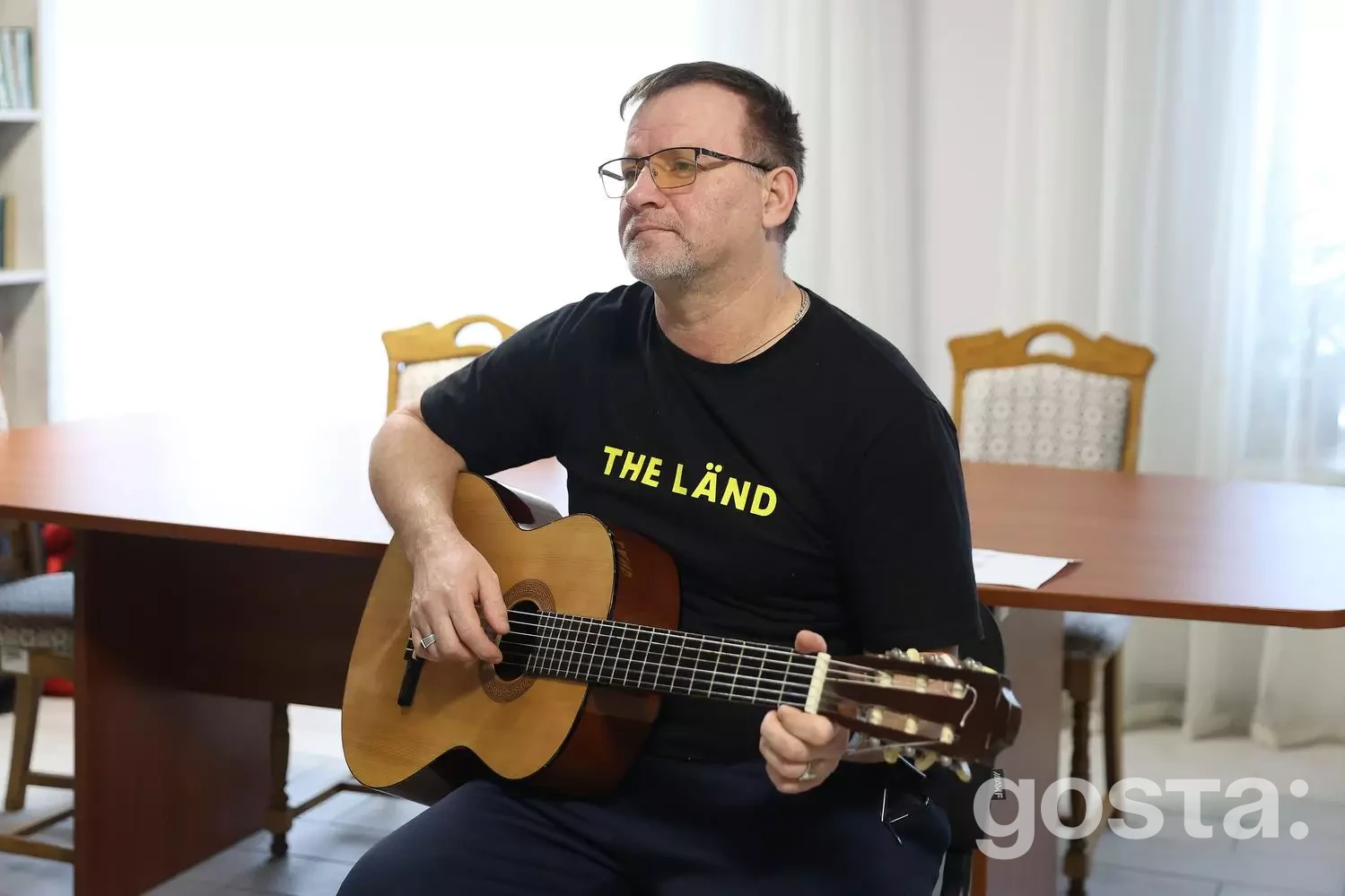 На зображенні чоловік грає на гітарі у реабілітаційному центрі, частина програми «Перезавантаження 2.0».