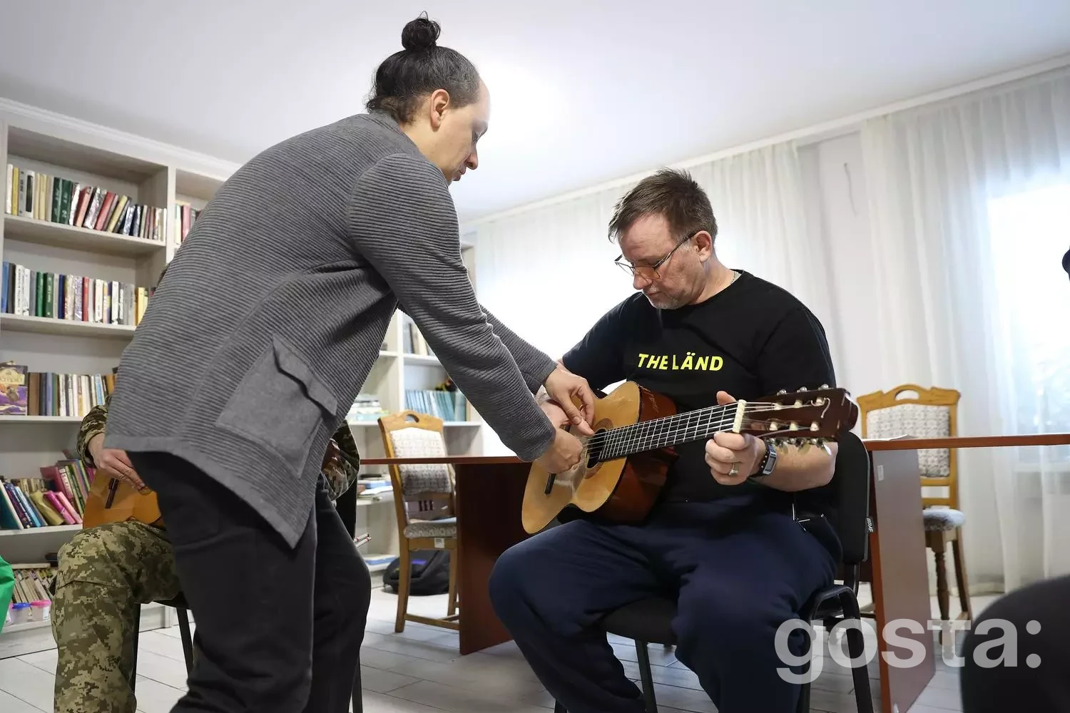 Особа на занятті з гри на гітарі в рамках реабілітаційної програми для ветеранів у центрі МВС України «Пуща-Водиця».