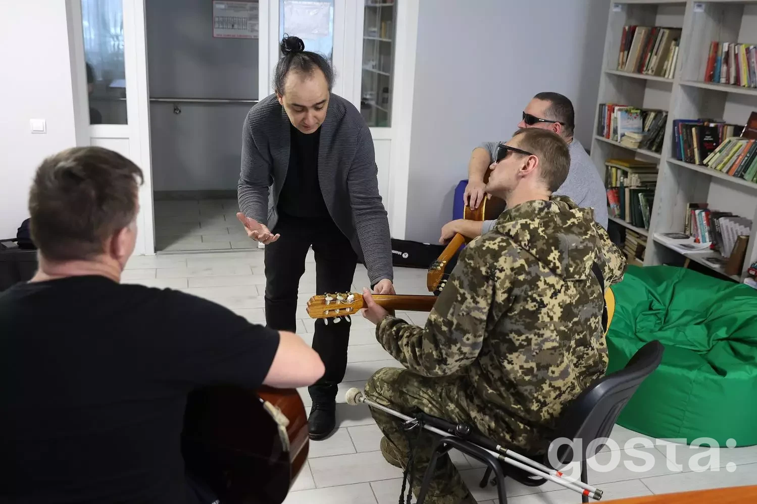 Ветерани у камуфляжі та цивільному одязі займаються музичною терапією у реабілітаційному центрі.