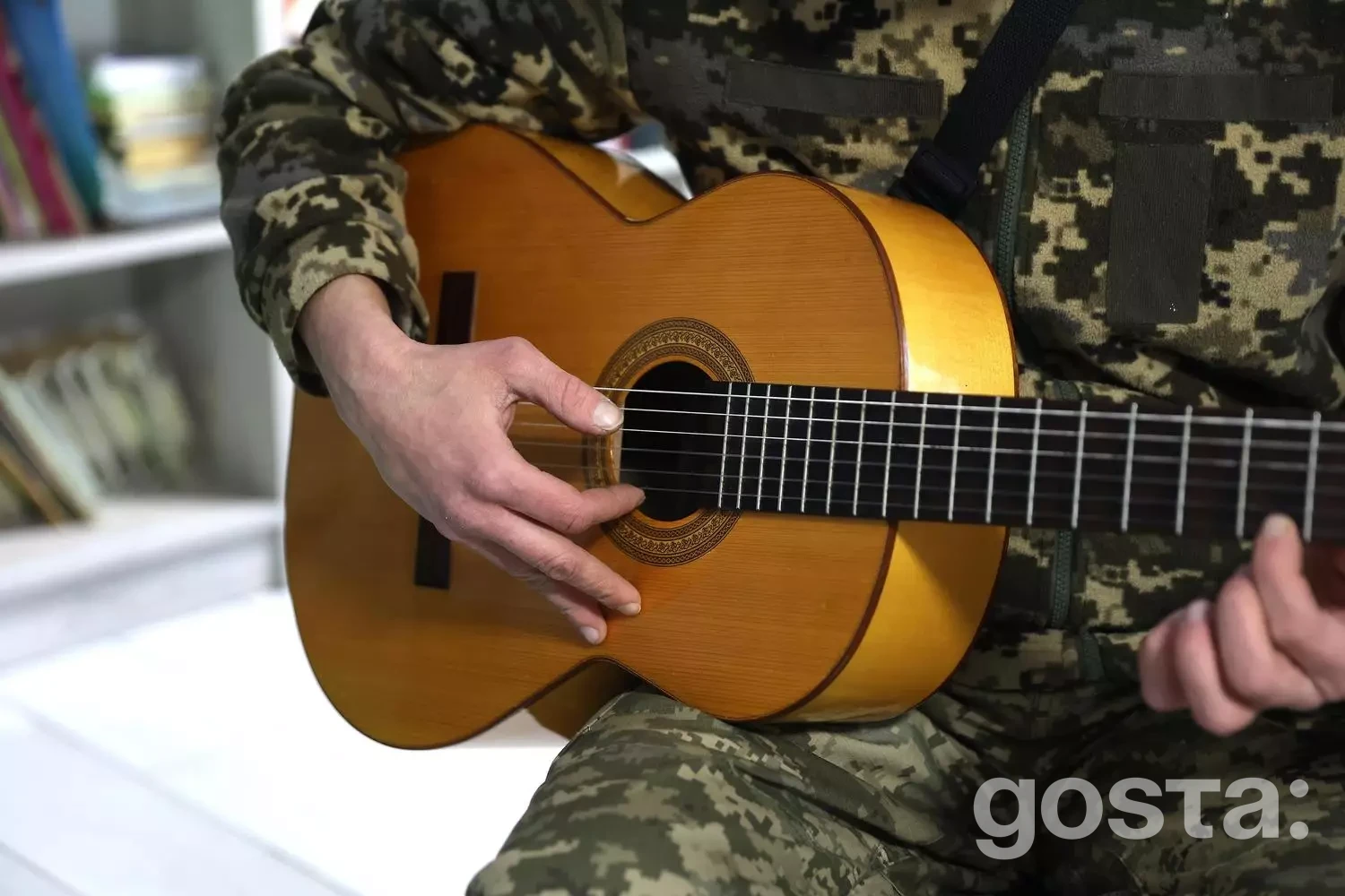 Людина у військовій формі грає на гітарі в рамках реабілітаційної програми для ветеранів у медичному центрі.