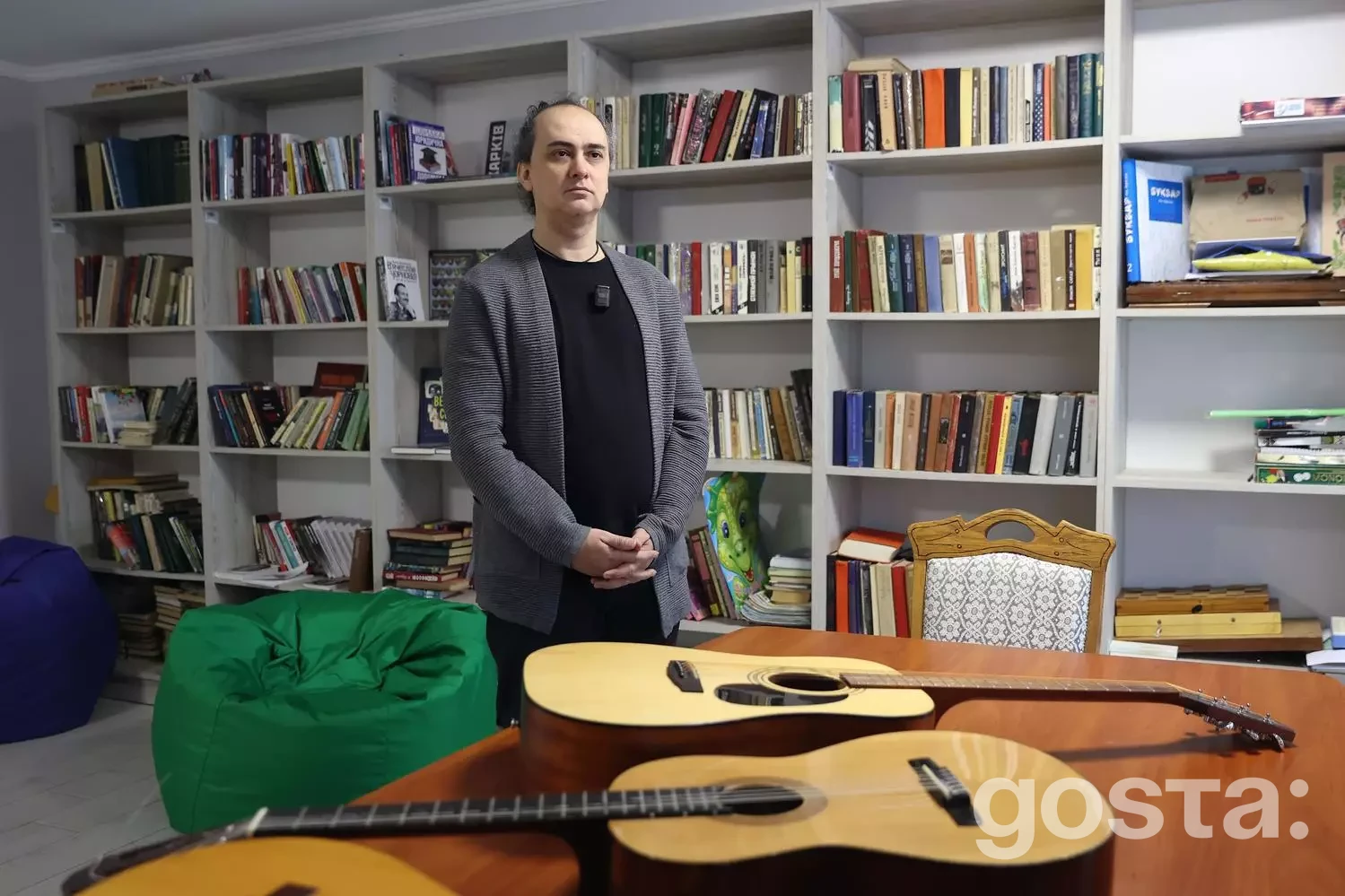 Чоловік у кімнаті з гітарами та книжковими полицями для програми "Перезавантаження 2.0" у реабілітаційному центрі.