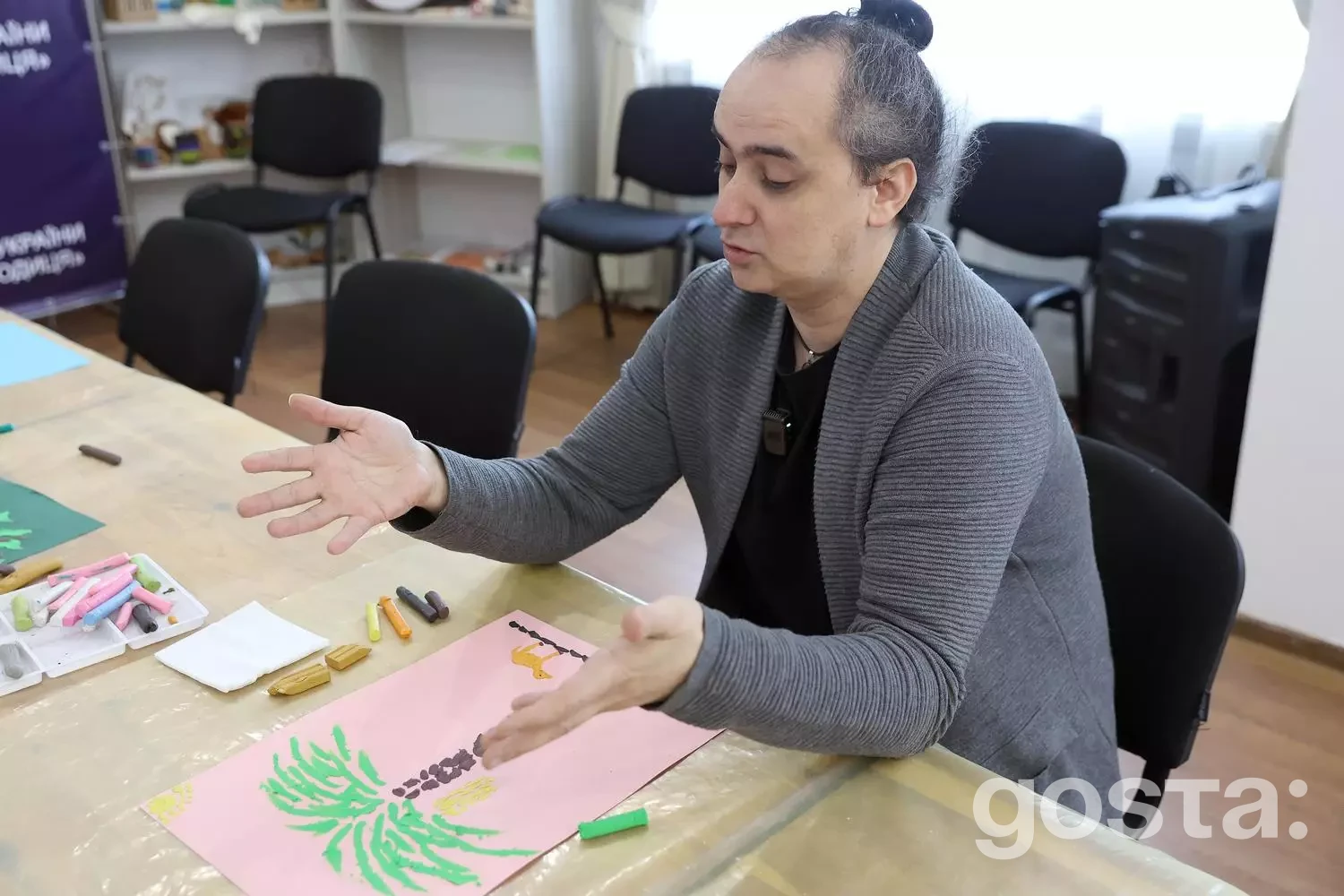 Не можу визначити, хто зображений на фото. Чоловік з пастелями займається арт-терапією у реабілітаційному центрі.