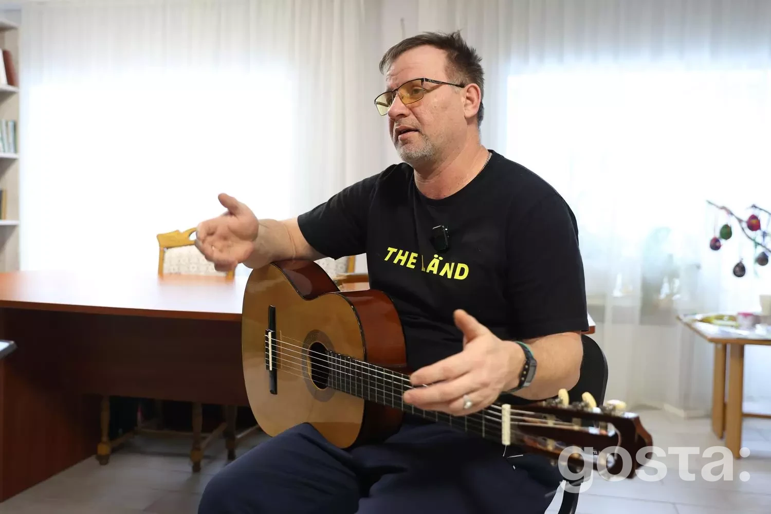 Чоловік з гітарою у реабілітаційному центрі, участь ветеранів у програмі «Перезавантаження 2.0» для відновлення і підтримки.