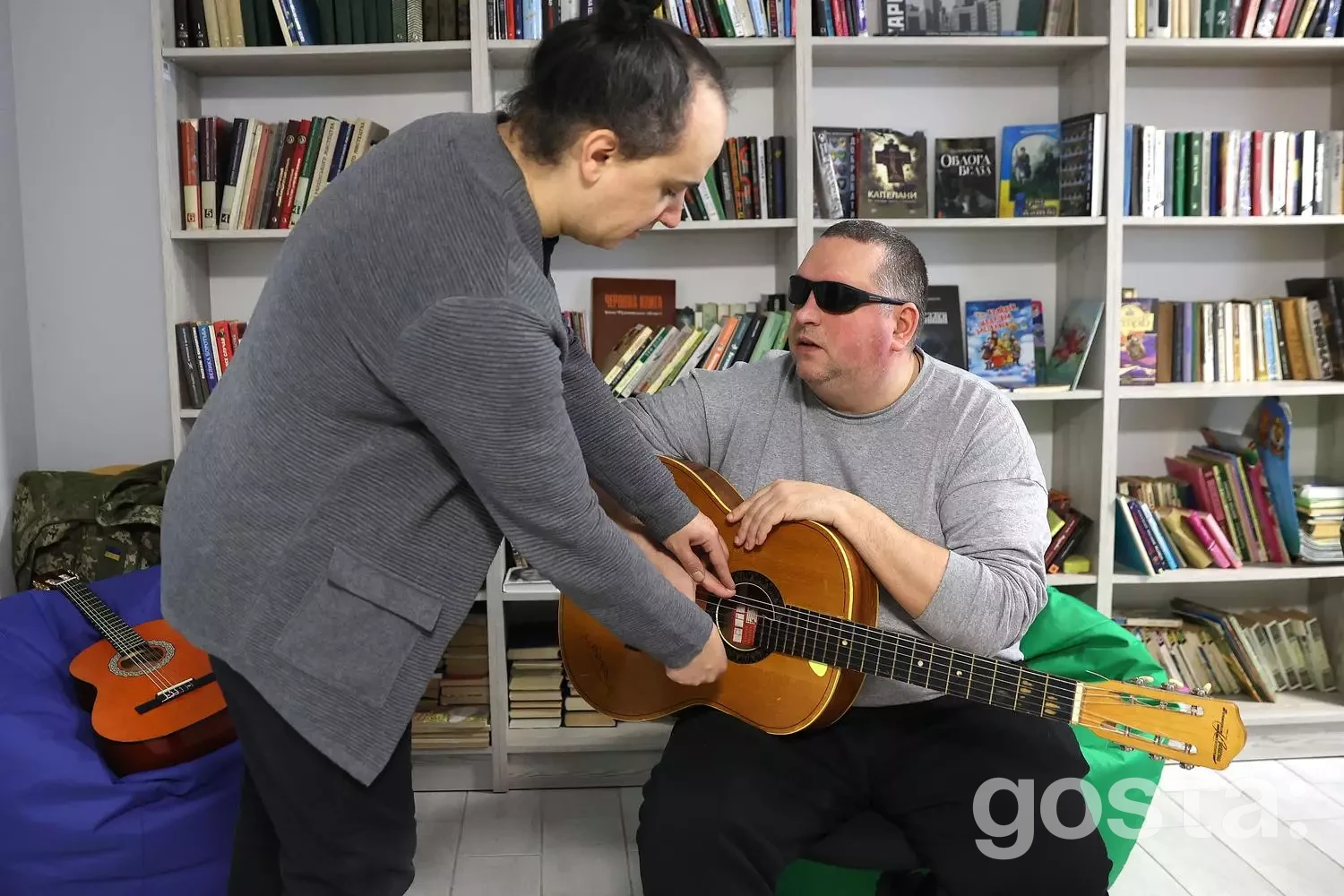 У медичному центрі двоє чоловіків, один із гітарою, займаються музичною терапією для реабілітації ветеранів.