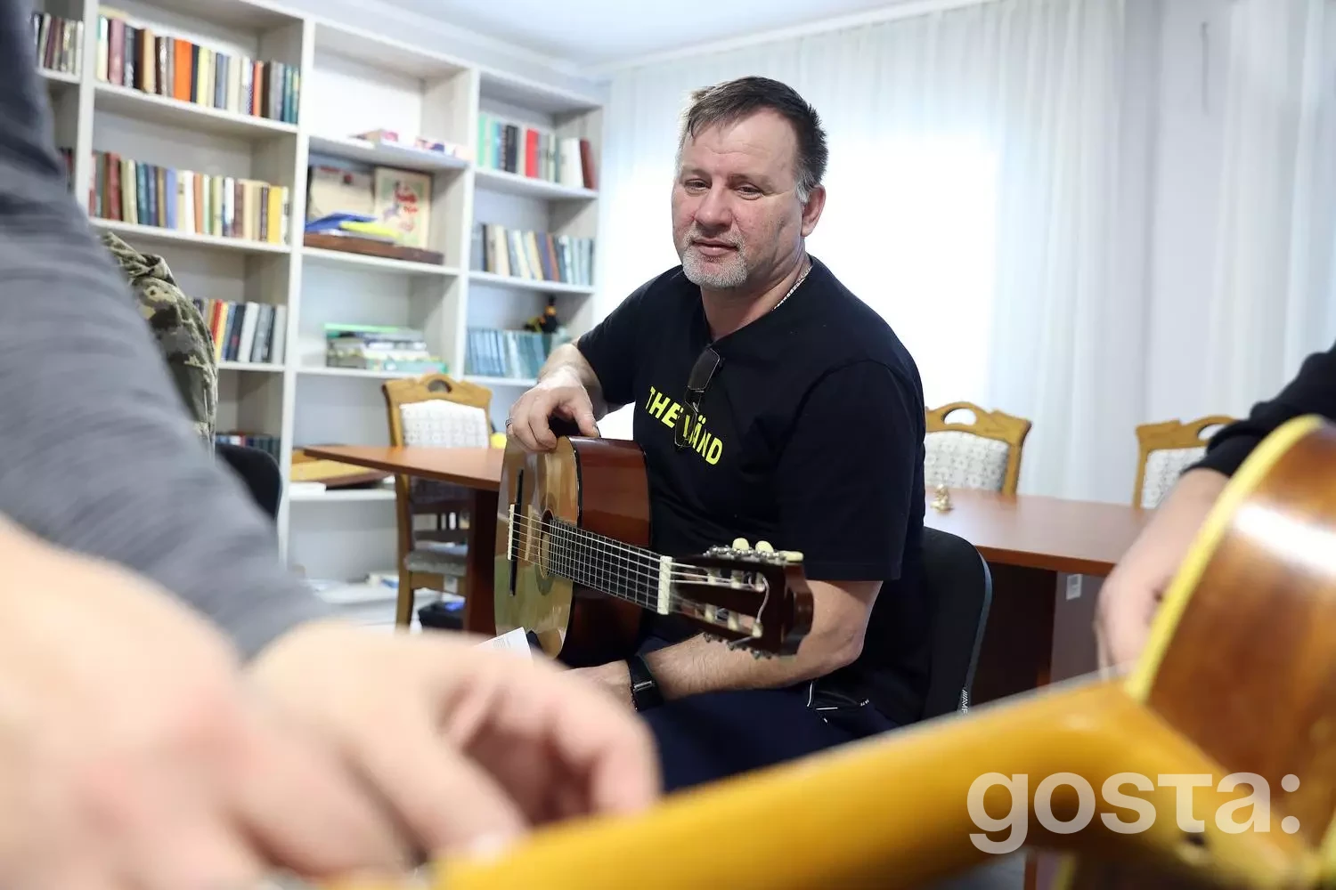 Не знаю, хто на цьому зображенні. Ветерани грають на гітарі у центрі реабілітації «Пуща-Водиця», 2026 рік.