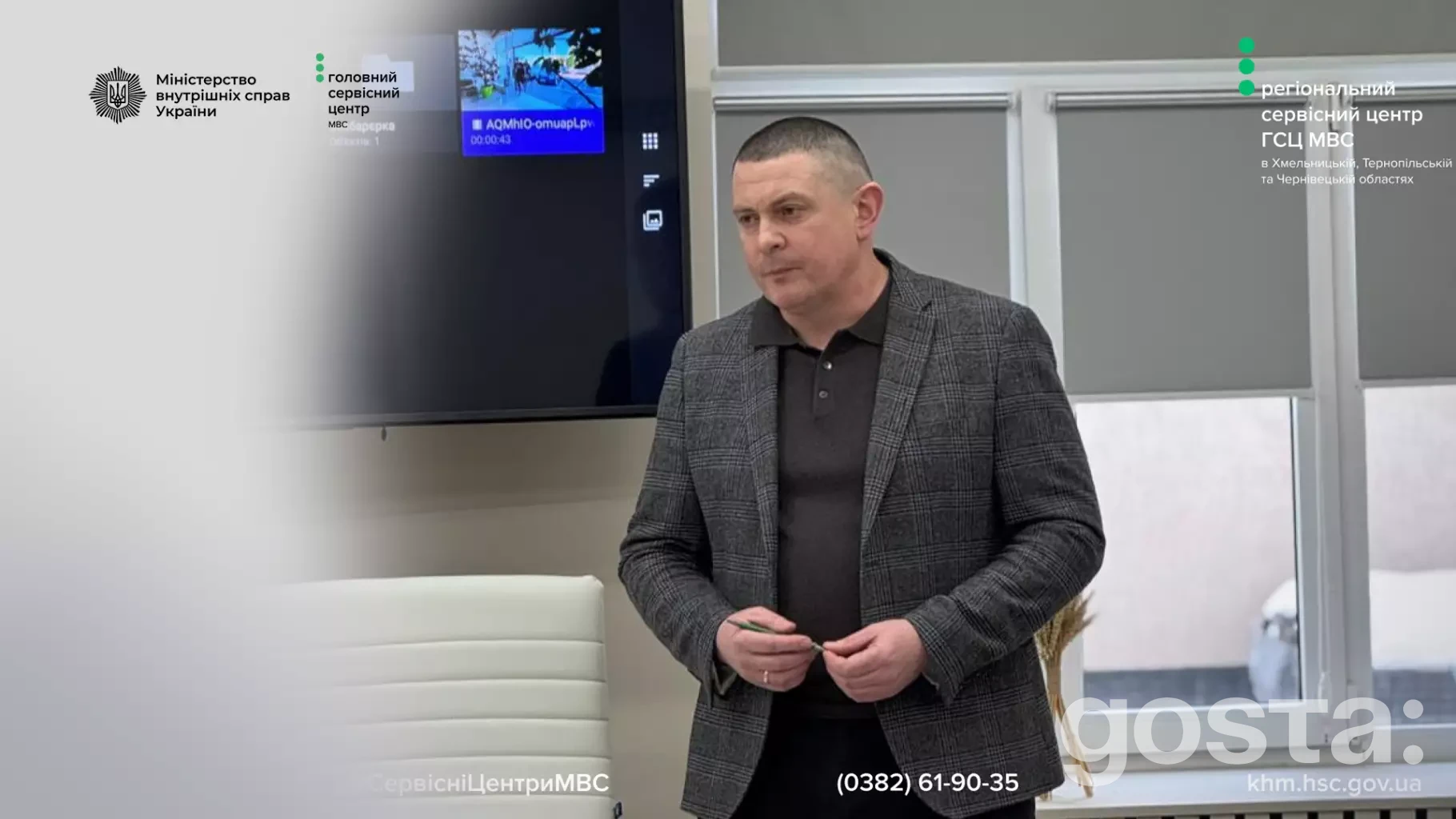 Не знаю, хто це. 
Чоловік стоїть у приміщенні. На екрані логотип МВС України та інформаційний слайд.