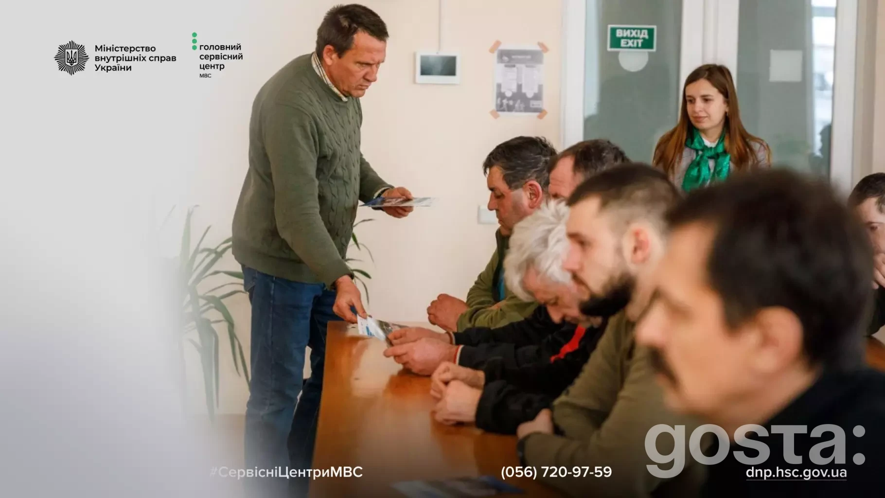 Люди сидять за столом у сервісному центрі МВС, обговорюючи безбар'єрні автошколи для ветеранів та людей з інвалідністю.